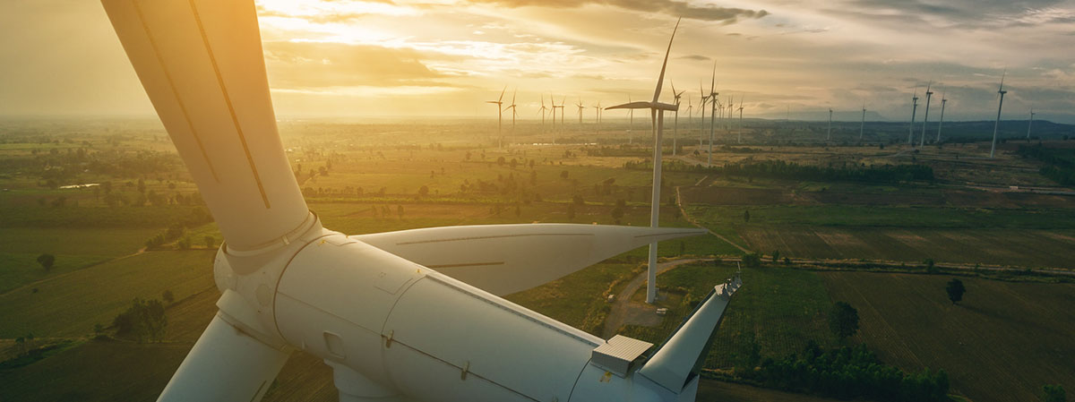 Wind turbines against sunset on horizon